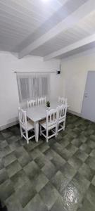 a white dining room with a table and chairs at LUZ BELLA 2 in Oberá