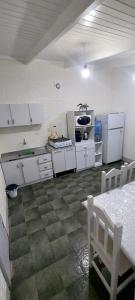 a kitchen with white appliances and a table and chairs at LUZ BELLA 2 in Oberá