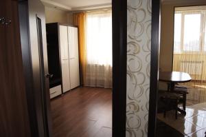 Cette chambre dispose d'un couloir avec une table et une porte. dans l'établissement Daily rent Apartments 5, à Ivano-Frankivsk
