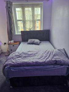 łóżko w sypialni z oknem w obiekcie Big double room with bathroom in 2 bedroom flat kitchen is shared w mieście Harrow on the Hill