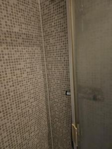 een badkamer met een douche en betegelde muren bij Big double room with bathroom in 2 bedroom flat kitchen is shared in Harrow on the Hill