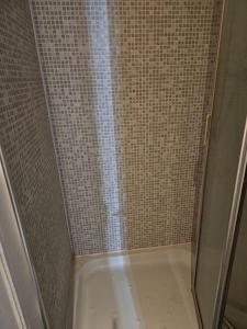 a shower with a glass door in a bathroom at Big double room with bathroom in 2 bedroom flat kitchen is shared in Harrow on the Hill