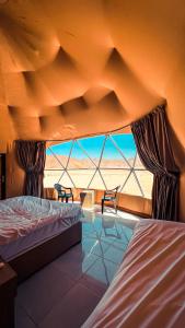 a bedroom with two beds and a view of the desert at Sama Wadi Rum in Wadi Rum