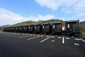 a row of portable toilets in a parking lot at HOTEL R9 The Yard 倉敷 in Kurashiki