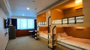 a room with three bunk beds and a desk at Koreana Hotel in Seoul