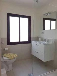 ein Bad mit einem WC, einem Waschbecken und einem Fenster in der Unterkunft El Reducto Suite in Arrecife