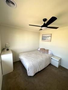 a bedroom with a bed and a ceiling fan at Coastal Oasis - 10 mins to Torquay, 10 mins to Geelong ! in Mount Duneed