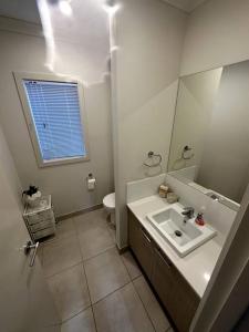 a white bathroom with a sink and a toilet at Coastal Oasis - 10 mins to Torquay, 10 mins to Geelong ! in Mount Duneed