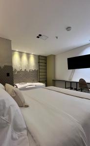 a bedroom with two beds and a flat screen tv at Sonata 44 Hotel Laureles in Medellín