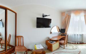 a living room with a table and a mirror at Kristina Hotel in Zaporozhye