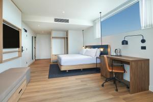 a hotel room with a bed and a desk and a computer at Hilton Garden Inn Busselton in Busselton