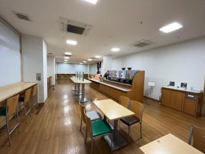 una habitación vacía con mesas y sillas y una cafetería en Hotel Alpha-One Niihama, en Niihama