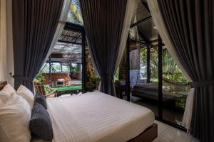 a bedroom with a bed in a room with windows at Daya Villa in Kampot