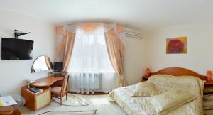 a bedroom with a bed and a desk and a window at Kristina Hotel in Zaporozhye