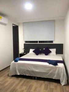 um quarto com uma cama grande e almofadas azuis em Apartasuite 10-72. 2 em Santa Marta