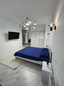 a bedroom with a blue bed and a tv at Уютная квартира на набережной! in Astana