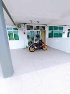 a motorcycle parked in a parking lot in a building at Manjung Point Homestay in Seri Manjung