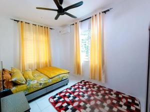 a bedroom with a bed and a ceiling fan at Manjung Point Homestay in Seri Manjung
