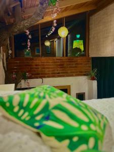 a room with a bed with a green pillow at Casa del árbol - Mitad del mundo in Quito