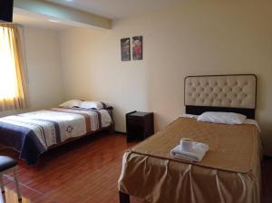 a hotel room with two beds and a window at hospedaje kayros in Arequipa