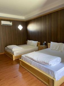 two beds in a room with wooden walls at Khách sạn - Nhà hàng Hoàng Phúc in Tuy Phong