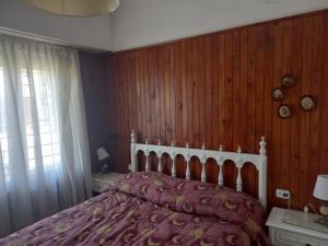ein Schlafzimmer mit einem Bett und einer Holzwand in der Unterkunft Marina in Mar del Plata