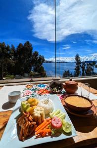 a plate of food on a table with a view at Amantani Samary Lodge in Amantani