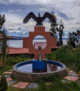 une statue d'un aigle assis au sommet d'une fontaine dans l'établissement Amantani Samary Lodge, à Ocosuyo