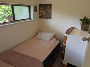 Habitación pequeña con cama y ventana en West Warburton Cottage, 