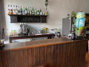 a bar with a counter with alcohol bottles on the wall at Hotel Doña Hilda in San Martín