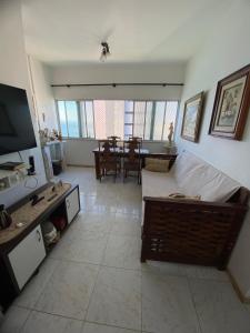 uma sala de estar com um sofá e uma televisão em Apartamento Vitória Vista ao Mar em Salvador