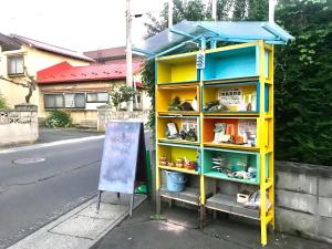 uma estante de livros amarela no lado de uma rua em Misato Memorial Hall - Vacation STAY 61405v em Hirakawa