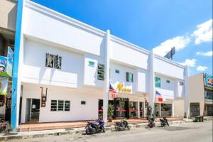 un edificio blanco con motocicletas estacionadas frente a él en Nexus Hotel, en Melaka