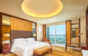 a bedroom with a bed and a desk and a large bed at Sheraton Zhoushan Hotel in Zhoushan