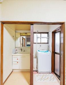 uma pequena cozinha com um frigorífico e um lavatório em Takeuchi Goya em Chiba