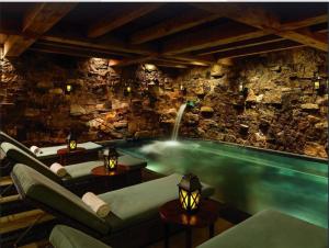 a swimming pool in a room with a stone wall at Ritz-Carlton Bachelor Gulch in Avon