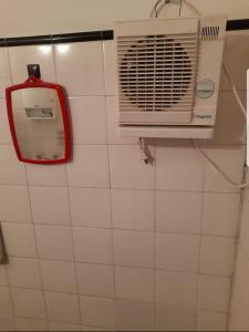 baño con ventilador y espejo en la pared en La casa de los nietos en Trelew