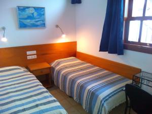 a hotel room with two beds and a window at Casa Marilan in Santa Cruz de la Palma