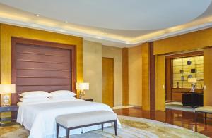 a bedroom with a large bed and a table and chairs at Sheraton Zhoushan Hotel in Zhoushan