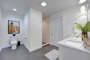 een witte badkamer met een wastafel en een toilet bij Newly Built Oasis close to IU 4bd/2.5ba in Bloomington