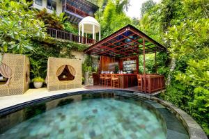 a swimming pool in the middle of a garden at Nandini Jungle by Hanging Gardens in Payangan