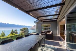 a patio with a table and chairs and a view of the ocean at Lordens Apartment 1 in Queenstown