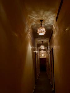 a hallway with two chandeliers and a long corridor at Casa Fausto’s in Azcorra