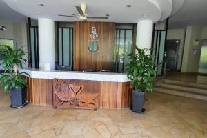 a lobby with a reception desk with two potted plants at Sky Residence -3 Bedrooms Condo at Cinta Sayang, Sungai Petani in Sungai Petani