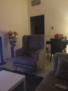 sala de estar con silla azul y mesa en 1 bedroom apartment en Fujairah