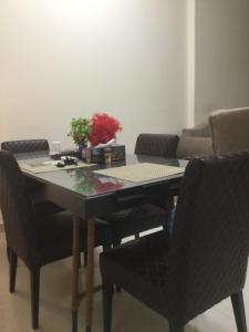 una mesa de comedor con sillas y una mesa con una planta. en 1 bedroom apartment, en Fujairah