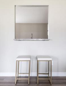 un espejo y dos taburetes en una habitación en Peaceful Modern Home near Avon, en Avon