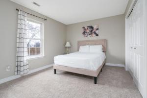 1 dormitorio con cama blanca y ventana en Peaceful Modern Home near Avon, en Avon