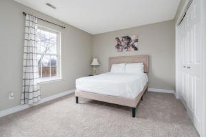a bedroom with a white bed and a window at Peaceful Modern Home near Avon in Avon