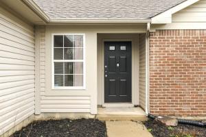 a house with a black door and a window at Peaceful Modern Home near Avon in Avon
